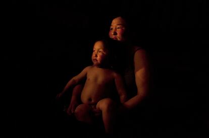 Erdene Tuya posa con su hijo Tuvchinj, de tres años, poco después de despertar. El pequeño abraza a una oveja durante la noche para hacer frente al fuerte frio.