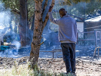 Un hombre contempla los restos de una chabola calcinada en un asentamiento en Lucena del Puerto (Huelva).