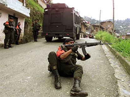 Un policía colombiano se dispone a disparar su arma en la zona de Medellín denominada Comuna 13 durante los enfrentamientos con la guerrilla.