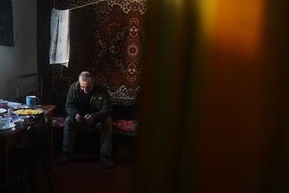 Alexander Karman consulta el móvil en la casa donde vivían en Huliaipole (región de Zaporiyia), el 2 de mayo de 2023.