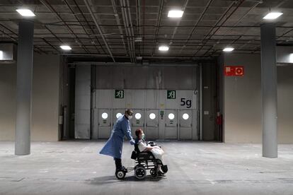 Personal sanitario traslada a una paciente en el hospital de campaña de Ifema, en Madrid.