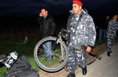 Un policía libanés carga con una de las bicicletas en las que viajaban los secuestrados a su paso por Zahle