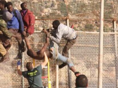 Algunos de los inmigrantes encaramados a la valla de Melilla.