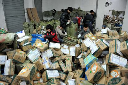 La octava edición del Día del Soltero en China ha batido de nuevo todos los récords de compras. Esto se traduce en el reparto de más de 600 millones de paquetes, todo un reto logístico. En la imagen, trabajadores chinos clasifican cajas de mercancías en una compañía de reparto en Lin'an, provincia de Zhejiang.