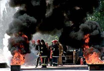 Los bomberos intentaban controlar ayer con extintores un fuego de combustibles líquidos en la factoría de Repsol-YPF en Pinto.