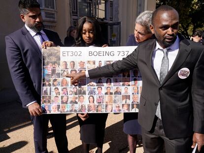 Paul Njoroge, right, points to photos of his wife and three children that were killed in the 2019 crash of Ethiopian Airlines 737 Max aircraft after a federal court hearing in Fort Worth, Texas, Thursday, Jan. 26, 2023.