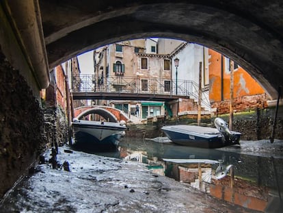 Dos botes encallados en un canal de Venecia por la baja marea, este martes.