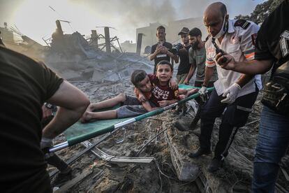 Un grupo de rescate palestino traslada a dos hermanos heridos tras un ataque aéreo israelí, el miércoles en Gaza.