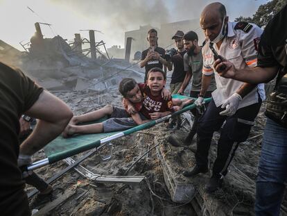 Un grupo de rescate palestino traslada a dos hermanos heridos tras un ataque aéreo israelí, el miércoles en Gaza.