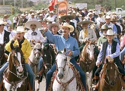 El presidente mexicano, Vicente Fox (centro), pasea a caballo por la localidad de Dolores durante las celebraciones del Día de la Independencia.