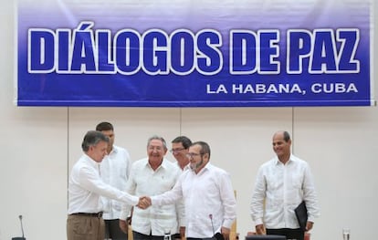 Santos y Timochenko se dan la mano ante Raúl Castro, en La Habana.