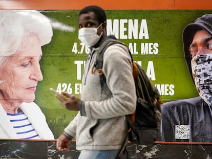 Un hombre pasa ante el cartel contra los menores extranjeros colocado por Vox en una estación de tren de Madrid.