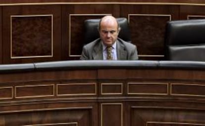 El ministro de Economía, Luis de Guindos, e Interior, durante la sesión de control al Gobierno hoy en el Congreso de los Diputados.