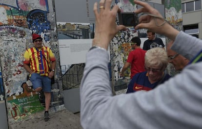 Un aficionado culé se fotografía delante de los restos del muro de Berlin