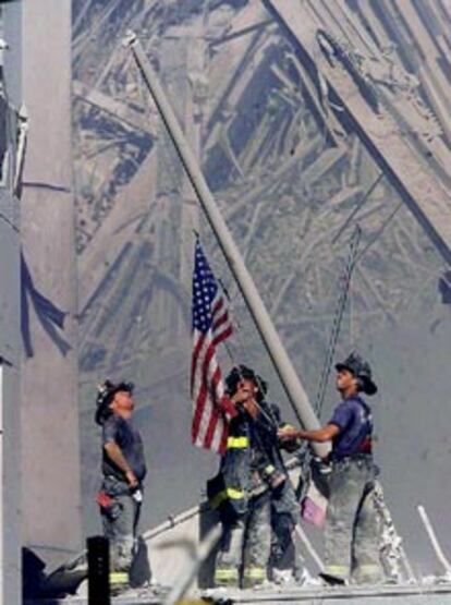 Los bomberos dedicados a las tareas de desescombro en la zona afectada por los atentados en Manhattan recuperan de entre las ruinas el mástil de una bandera del país.
(ASSOCIATED PRESS)