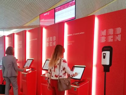 Dos viajeras tramitan su tarjeta de embarque en el área dedicada al Puente Aéreo en el aeropuerto de Madrid-Barajas.