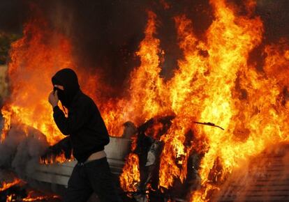Un activista pasa frente a una de las barricadas de Dale Farm, prendida en llamas.