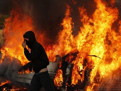 Un activista pasa frente a una de las barricadas de Dale Farm, prendida en llamas.