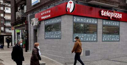 Viandantes caminan frente a un restaurante Telepizza en Madrid. 