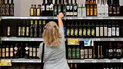 Una clienta de un supermercado español elige una botella de aceite de oliva.