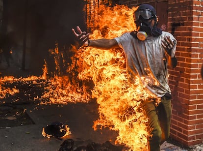 Un manifestante de la oposición en llamas tras haber explotado un tanque de gas de una moto de la policía durante una protesta contra Maduro el 3 de mayo de 2017 en Caracas.