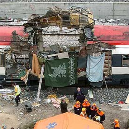 Equipos de emergencia, junto a uno de los vagones destrozados en Atocha en los atentados del 11-M.