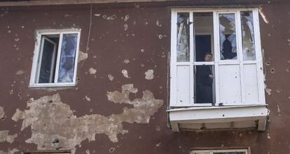 Un hombre se asoma a la ventana tras los ataques en Semyonovka, en la región separatista de Donetsk.
