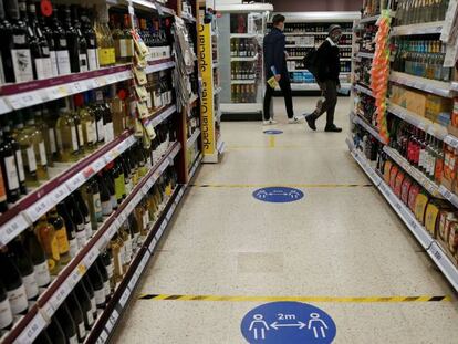 Pegatinas con la distancia física sugerida, en una tienda Tesco en Londres, este martes.