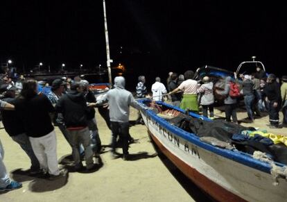 Varias personas sacan botes de pesca del agua durante la alerta de tsunami en Valparaíso.