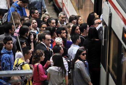 Numerosos pasajeros esperan para entrar en un tren, en la madrileña estación de Atocha a primera hora de hoy