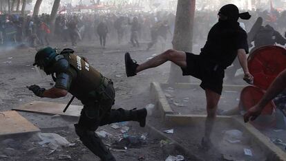 Manifestantes y carabineros se enfrentan durante la manifestación en Santiago, este martes. 