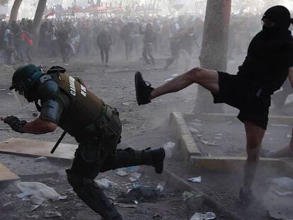 Manifestantes y carabineros se enfrentan durante la manifestación en Santiago, este martes. 