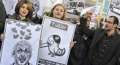 Dos jóvenes sostienen unas caricaturas del primer ministro turco, Recep Tayyip Erdogan.