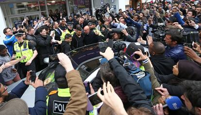 El centrocampista argelino del Leicester City, Riyad Mahrez intenta entrar en su coche, ante una multitud de fans después de almorzar con sus compañeros de equipo en el centro de Leicester.