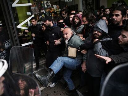 Manifestantes contra la apertura comercial en domingos se enfrentan a antidisturbios en Atenas.
