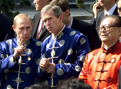 El presidente de Estados Unidos George W. Bush (c), el de Rusia Vladimir Putin (i) y el de China Jiang Zemin, todos vestidos con una chaqueta tradicional china, conversan antes de posar para foto de grupo de la cumbre del APEC (Conferencia Económica Asia - Pacífico), celebrada en Shangai (China), en octubre de 2001.