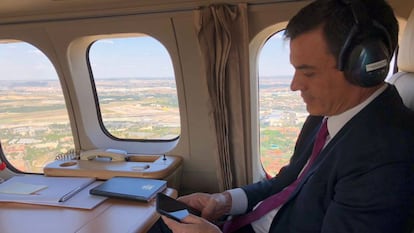 El presidente del Gobierno, Pedro Sánchez, mira su 'smartphone' en un viaje oficial.