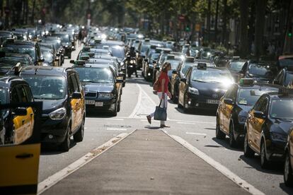 Miles de Taxis bloquen la Gran Via, en la imagen, una ciudadana cruza la Gran Via repleta de taxis a la altura de la calle Roger de Lluria.