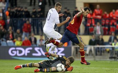 Benzema, entre Casillas y Busquets.
