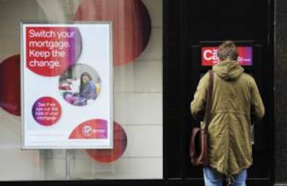 Un cliente saca dinero de un cajero automático de Virgin Money, en Londres, Inglaterra. EFE/Archivo