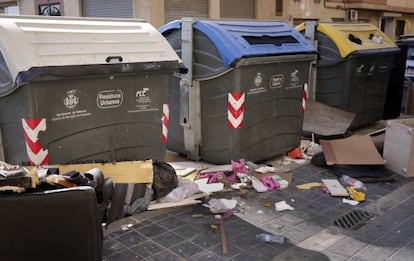 Basura en torno a unos contenedores en una calle de Valencia.