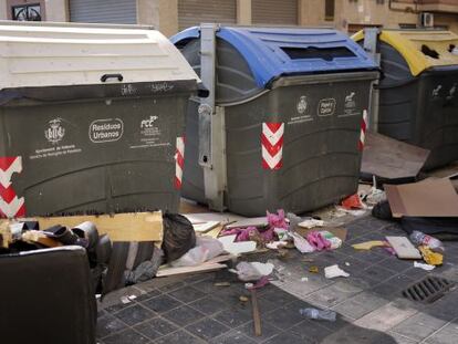 Basura en torno a unos contenedores en una calle de Valencia.