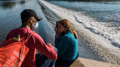 Una pareja inmigrante de Cuba espera intentar cruzar el Río Grande desde Ciudad Acuña, México, hacia Del Río, Texas, el domingo 19 de septiembre de 2021.