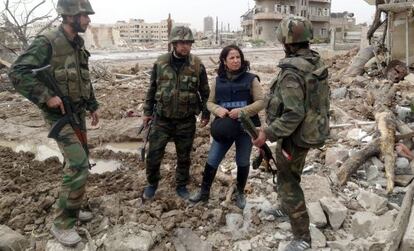 Una periodista conversa con soldados sirios entre escombros a las afueras de Damasco, en una fotograf&iacute;a cedida por la agencia oficial SANA.