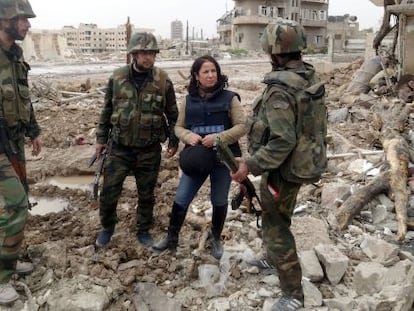 Una periodista conversa con soldados sirios entre escombros a las afueras de Damasco, en una fotografía cedida por la agencia oficial SANA.
