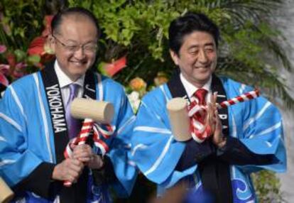 El titular del Banco Mundial, Jim Yong Kim (i), y el primer ministro nipón, Shinzo Abe (d), sonríen durante una ceremonia de apertura en la recepción de bienvenida de la quinta Conferencia sobre Desarrollo en África (TICAD V) de Tokio, en Yokohama (Japón).