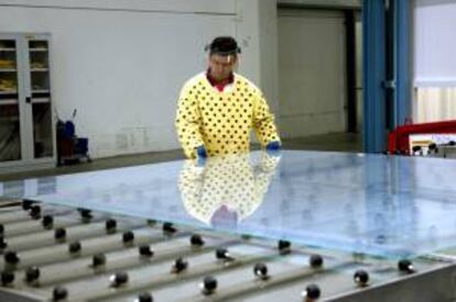 Un trabajador de la empresa T-Solar con uno de los paneles fotovoltaicos que se fabrican. EFE/Archivo