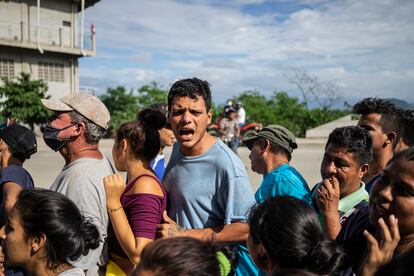 Damnificados por la tormenta forman en una fila para recibir comida.