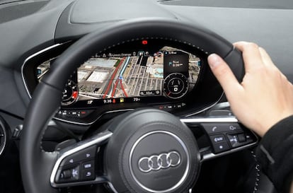 Un visitante prueba el tablero del Audi TTS, que muestra diferentes pantallas como mapa de navegación e instrucciones