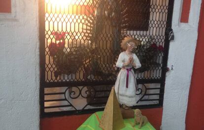 Santa Mari La Juaricua frente a un altar de la Virgen de Guadalupe.